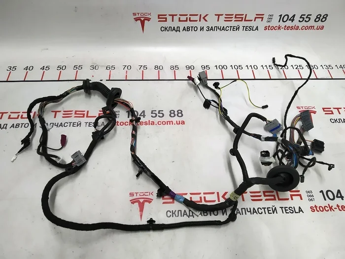 1004419-00-Uテスラ車の左フロントドアの配線。アメリカの電気自動車の電気回路の不可欠な部分であり、体の可動部分のさまざまなデバイスの動作を保証します。テスラモデルSで使用するために設計されています。フロント左ドアの配線は、電流伝導率を向上させる最新の素材で作られています。オンライン ストアで購入できる他のテスラ パーツと同様、これらは米国の有名ブランドのオリジナル製品です。この事実は、特別なマーキングによって確認されます。フロント左ドアの配線により、損傷した自動車部品をすばやく交換できます。テス